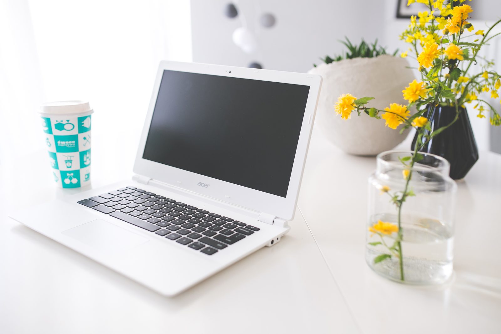 A laptop, notebook and coffee on a desk — a planning workspace